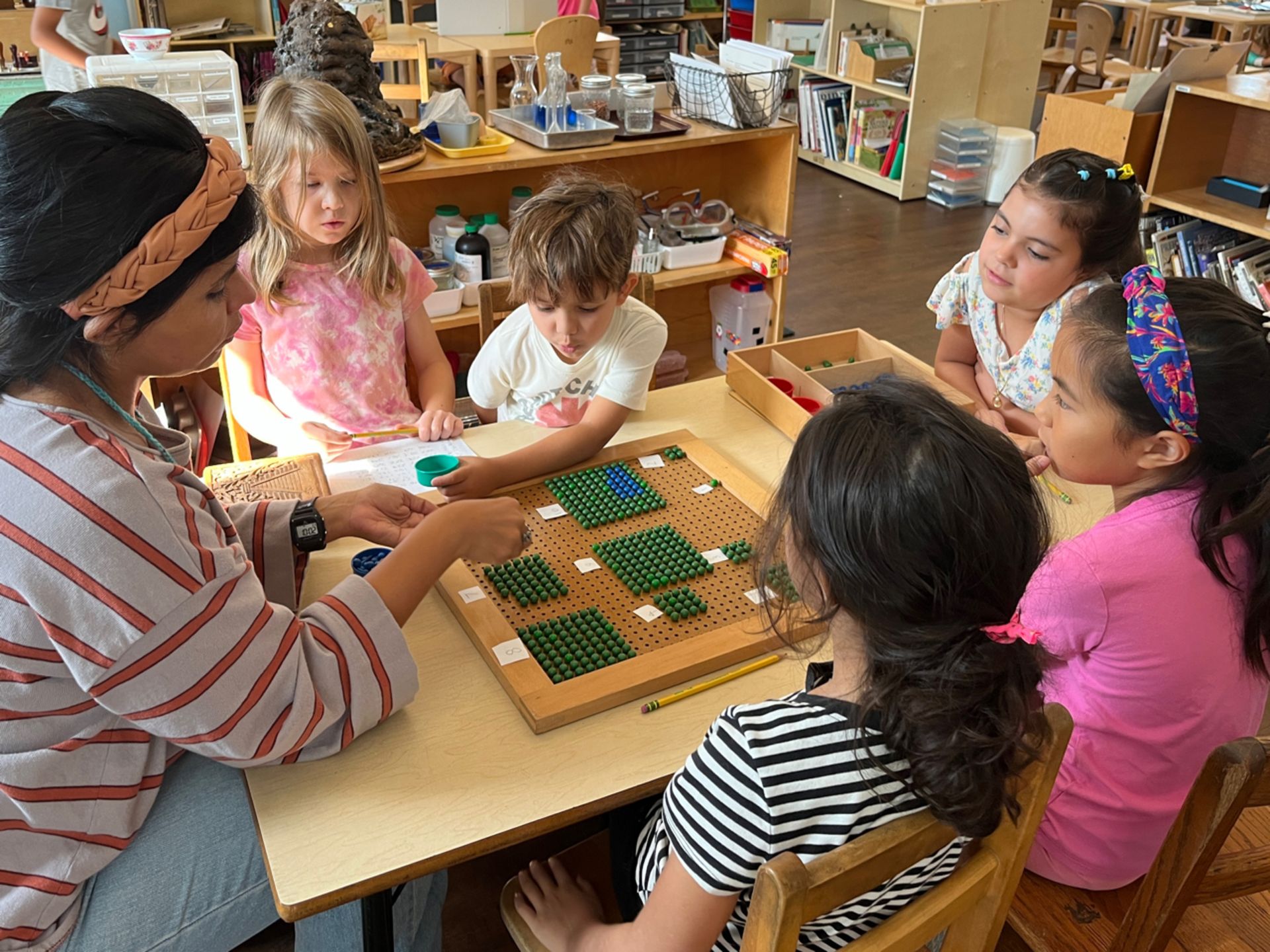 Montessori guide with children sitting on a table