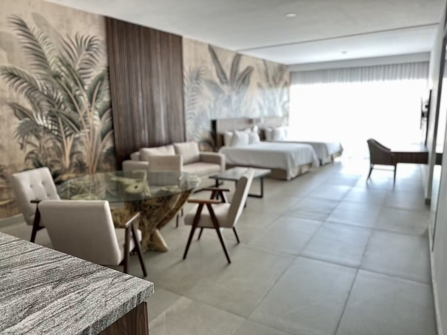 A hotel room with two beds , a table and chairs