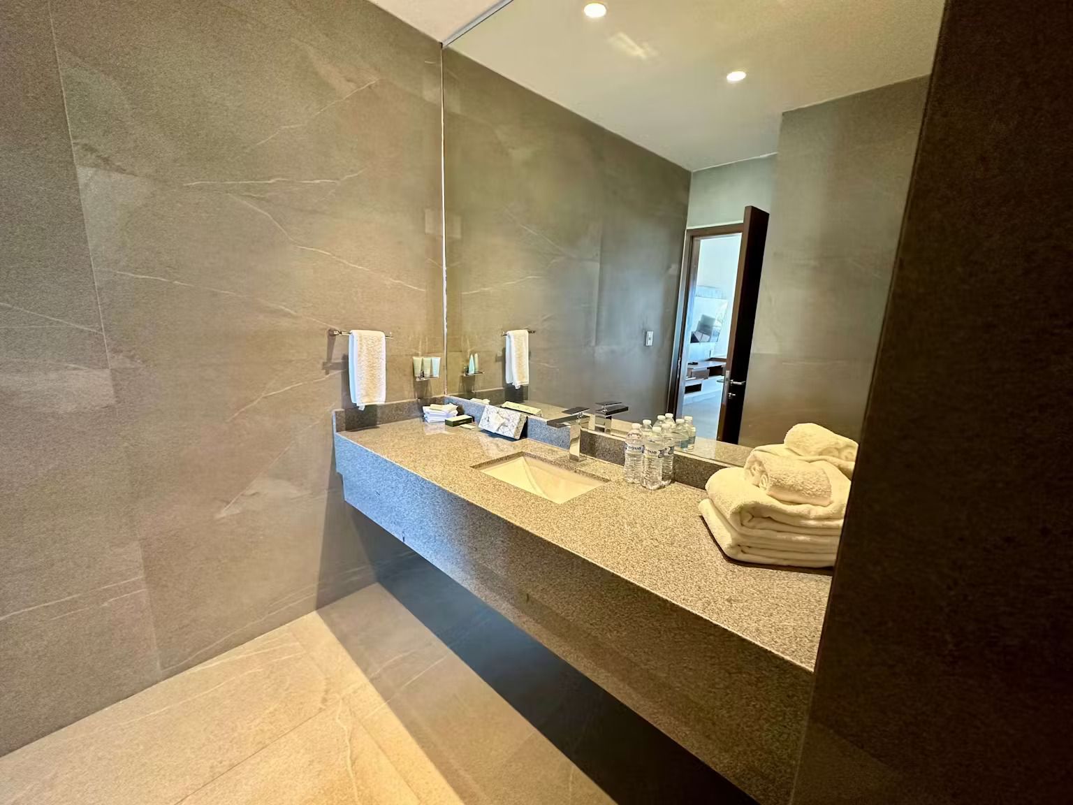 A bathroom with a sink and a large mirror.