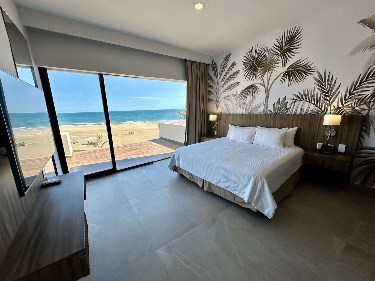 A hotel room with a king size bed and a view of the ocean.