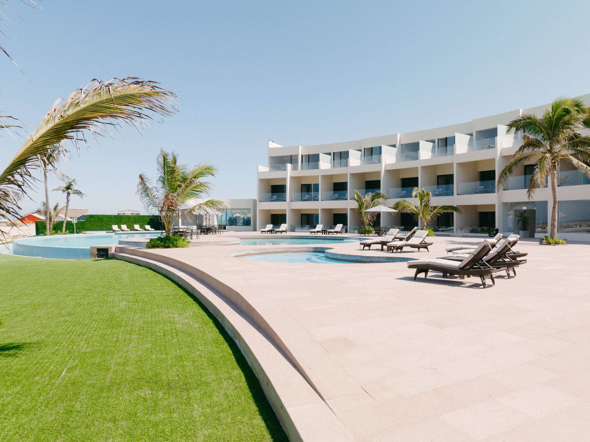 A large white building with a swimming pool in front of it