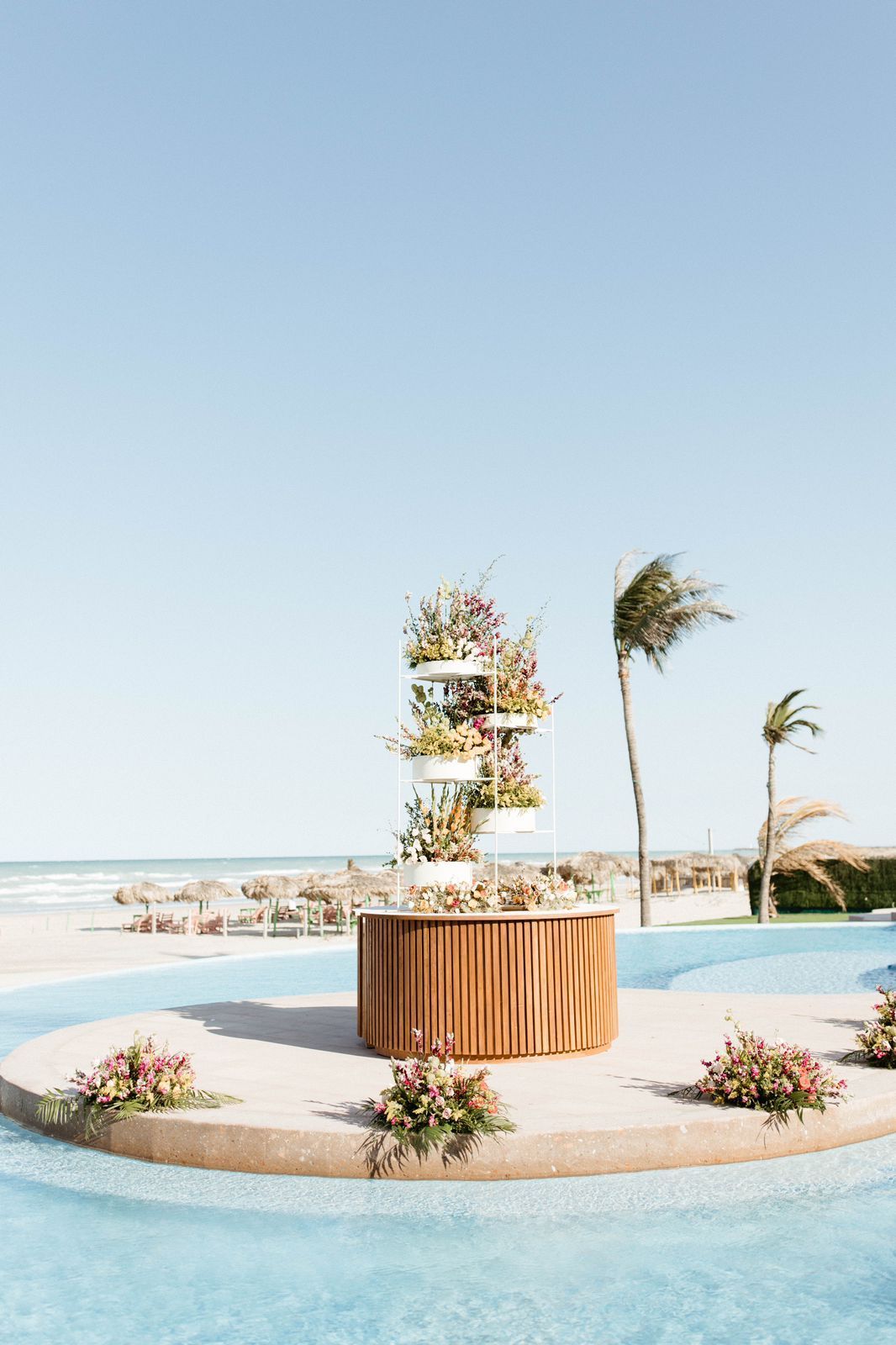 A wooden table with flowers on it is in the middle of a swimming pool.