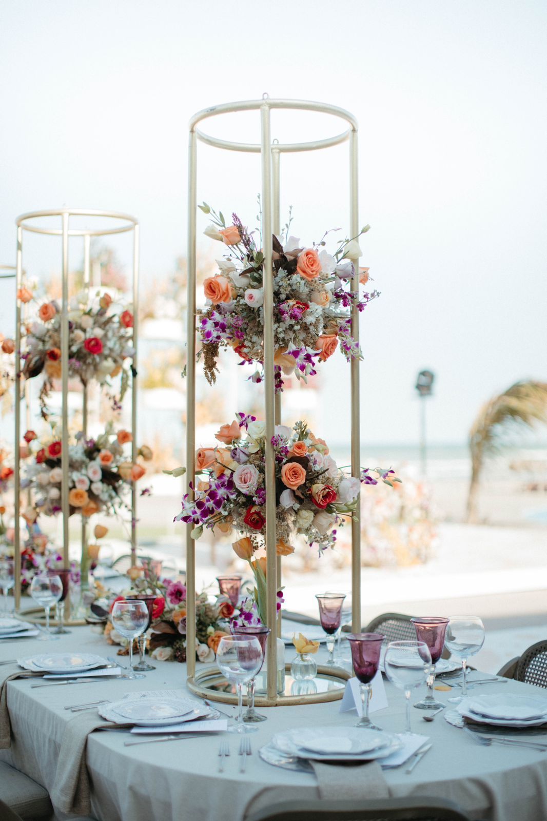 A table set for a wedding reception with flowers on it.