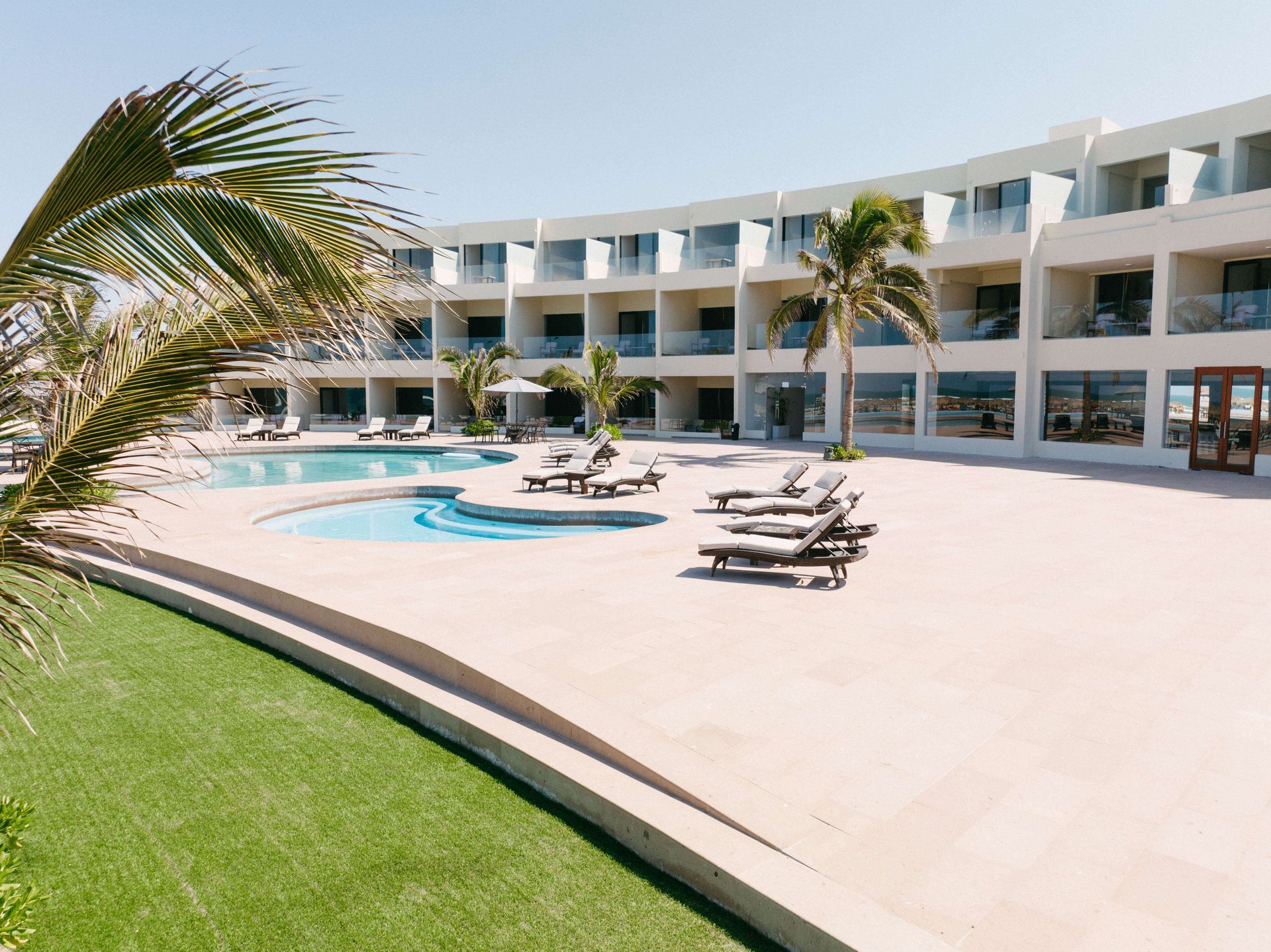A large building with a swimming pool in front of it