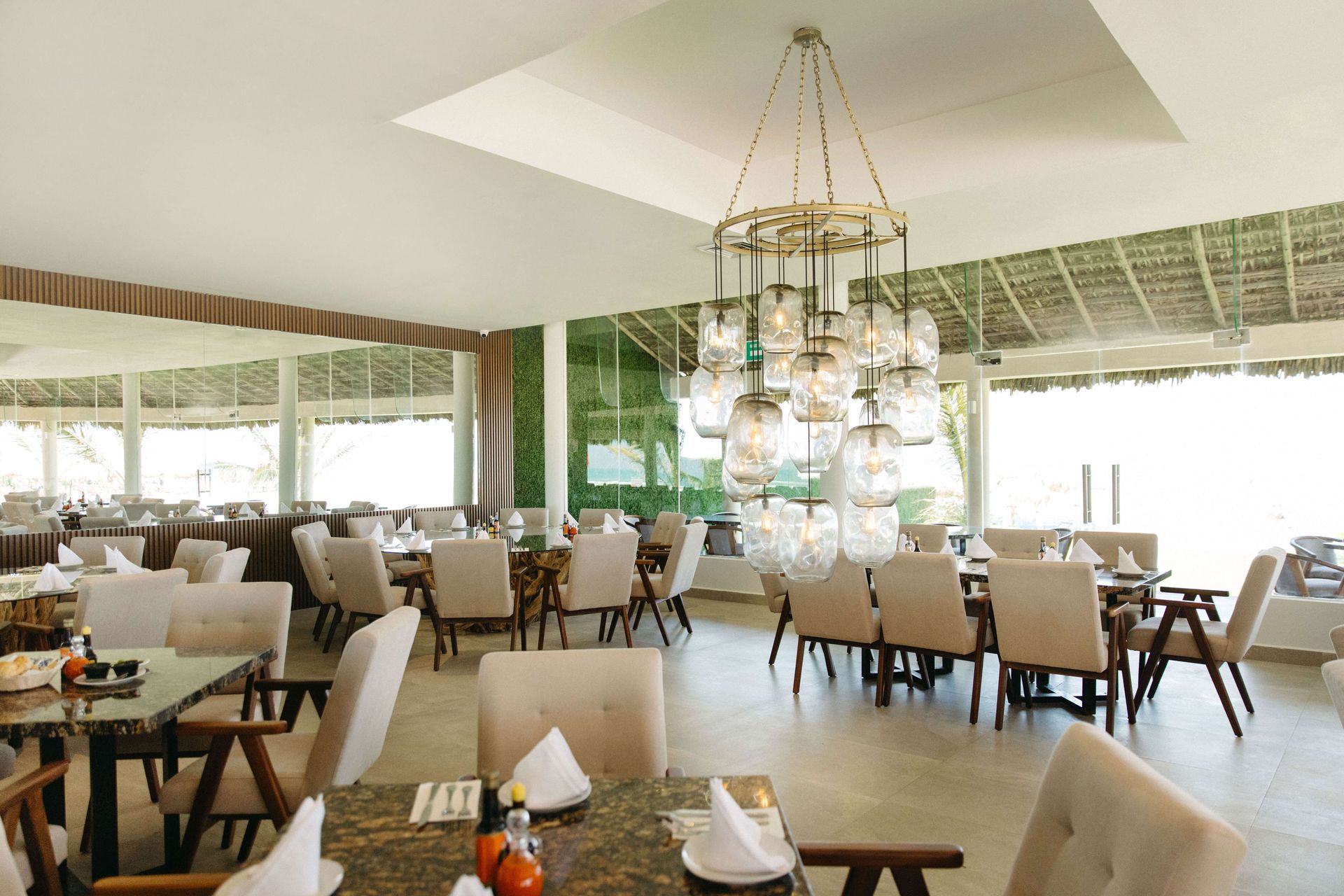 A restaurant with tables and chairs and a chandelier hanging from the ceiling.