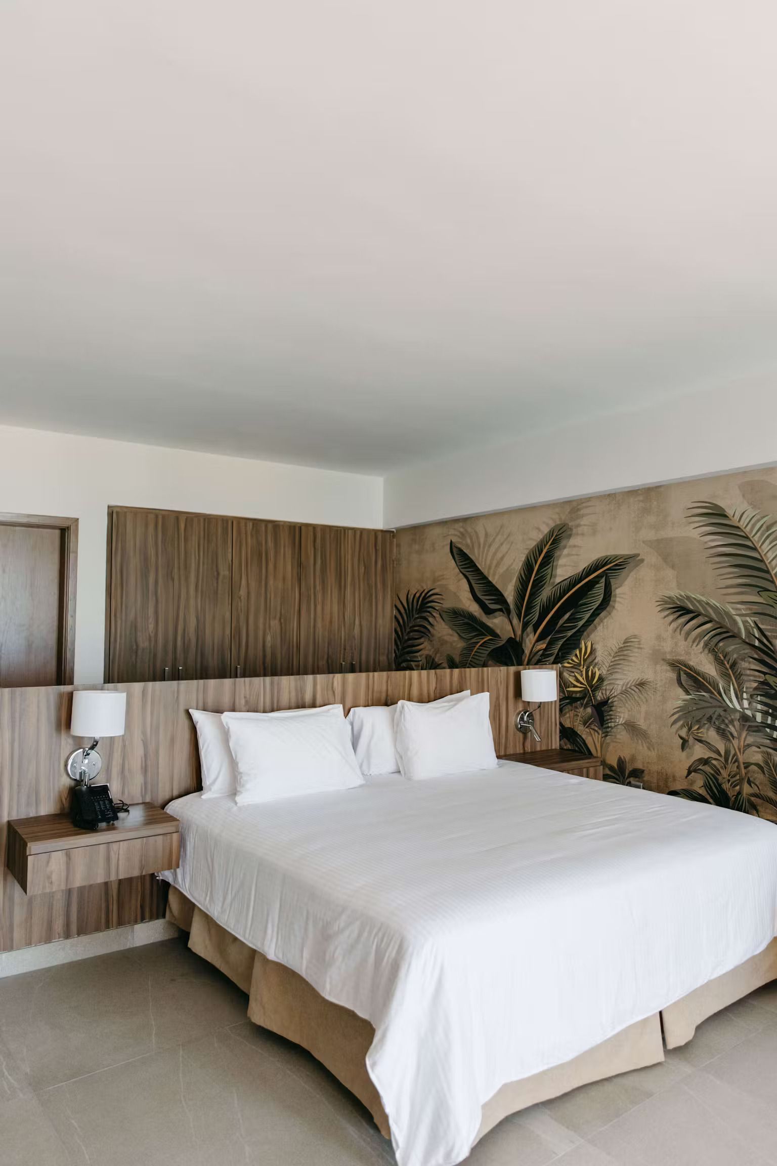 A hotel room with a large bed and a painting on the wall.