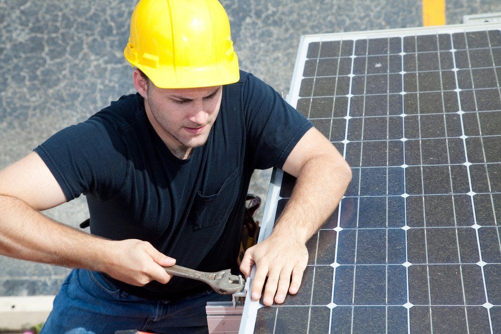 Solar Panel Installer in Yellow Hard Hat — Big Electrics in Redlynch, QLD