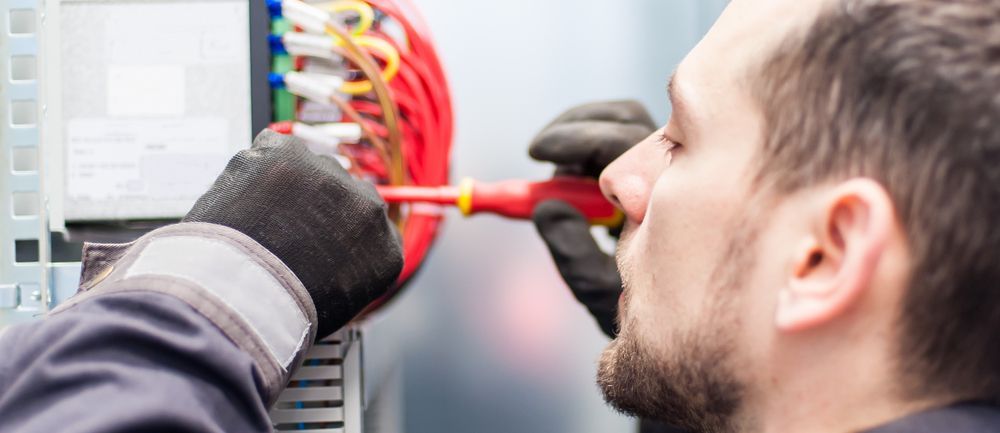 A Person Wearing Gloves Working — Big Electrics in Redlynch, QLD