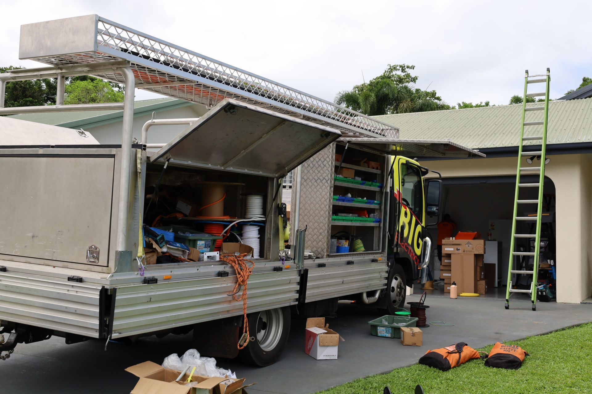 Solar Panel Installer on Rooftop Under Blue Sky — Big Electrics in Redlynch, QLD