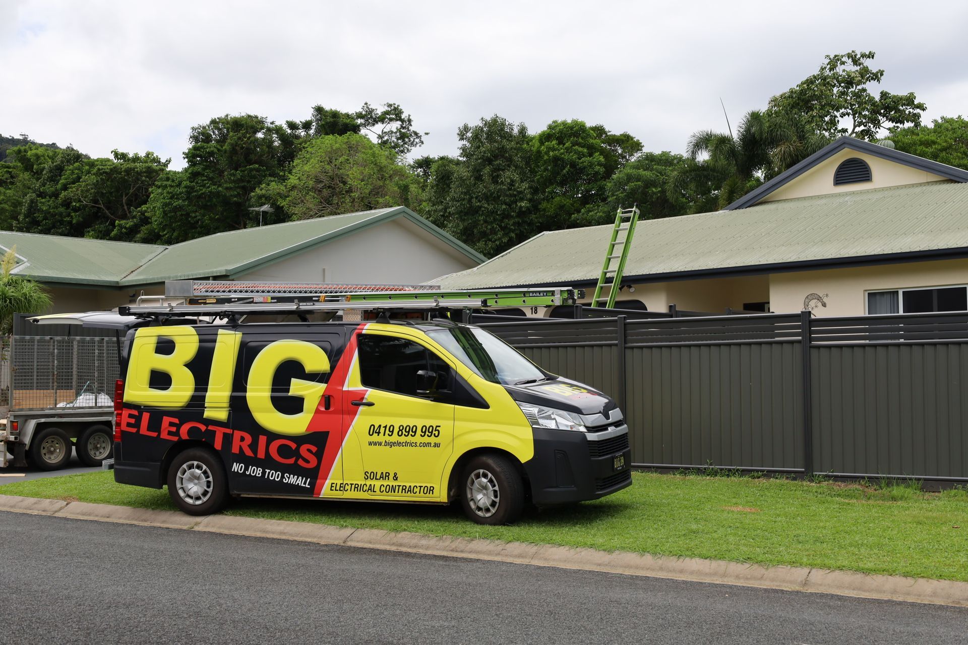 Solar Panel Installer in White Hard Hat Works on a Roof — Big Electrics in Redlynch, QLD