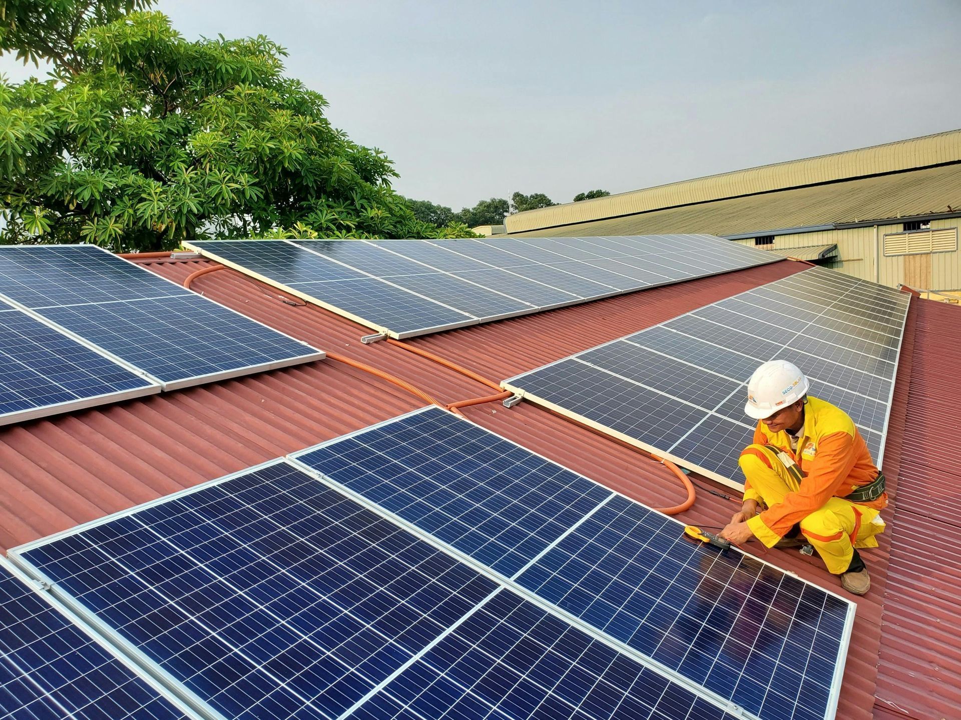 Solar Panel Installer in Safety Gear on a Roof — Big Electrics in Redlynch, QLD
