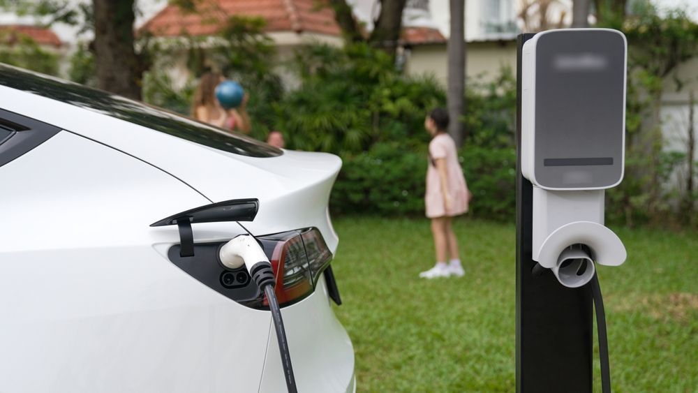 White Electric Car Charging Near a Charging Station — Big Electrics in Redlynch, QLD