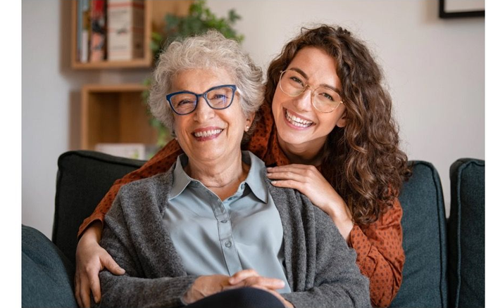 Close-up of a smiling mouth with white teeth, and wrinkled skin around the cheeks.