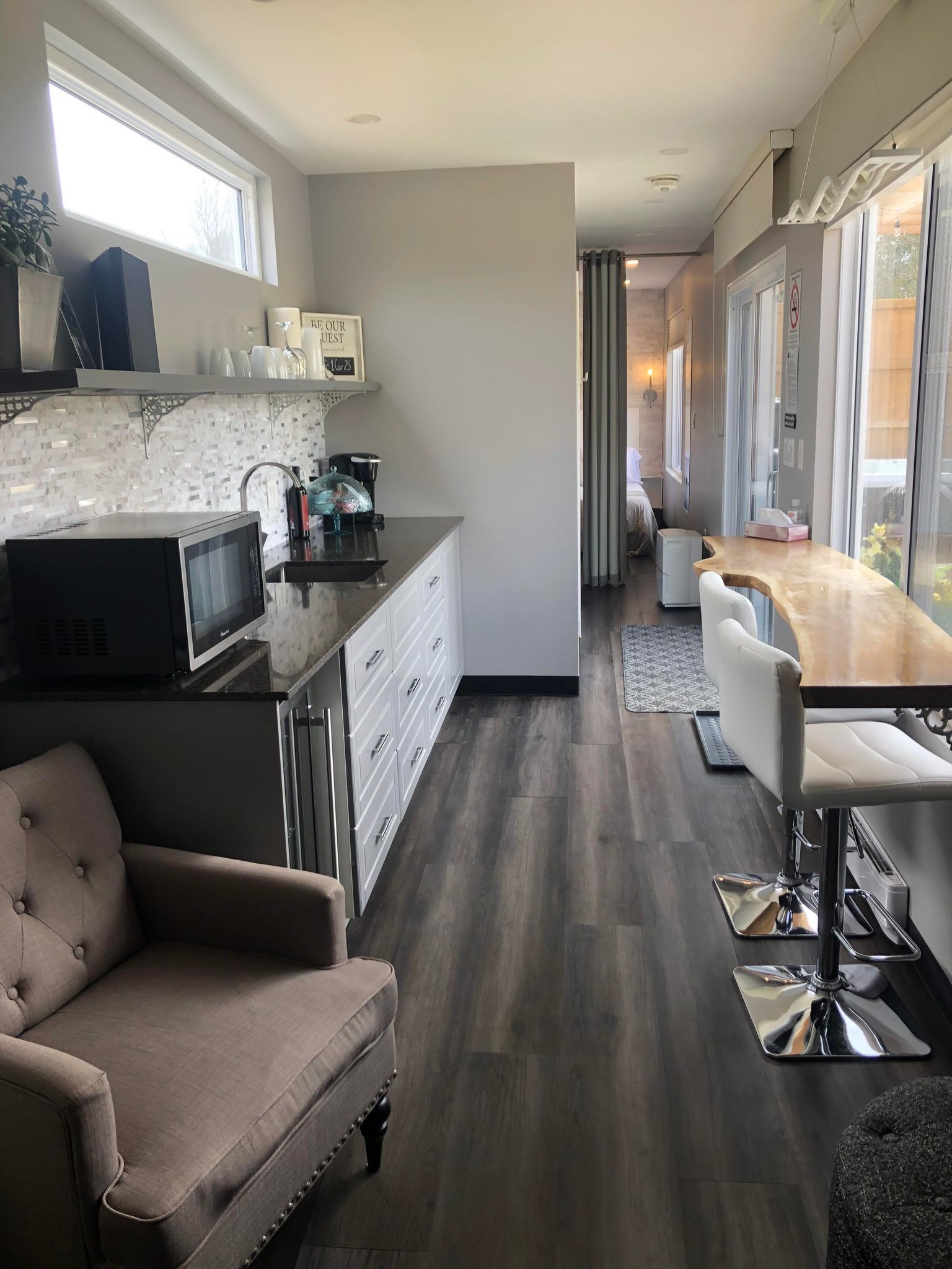 Kitchen and dining area with dark floors, white cabinets, and a long wooden table.