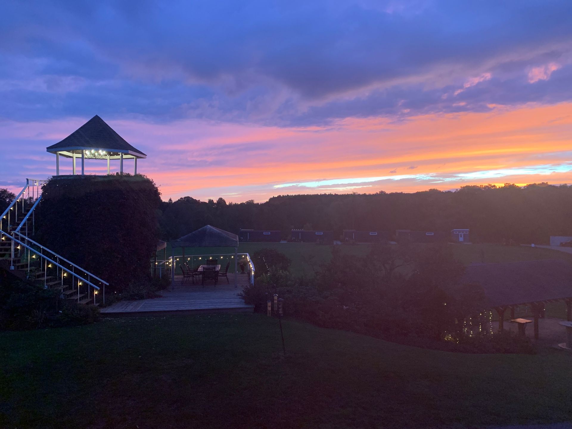 Sunset over gazebo and grounds, with vibrant pink and orange sky.
