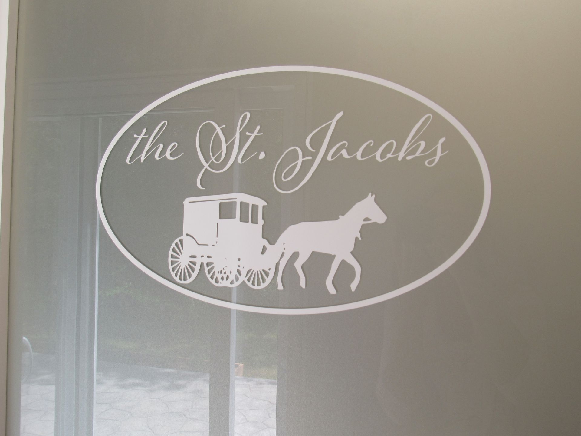 White logo on a frosted glass door. Oval contains 