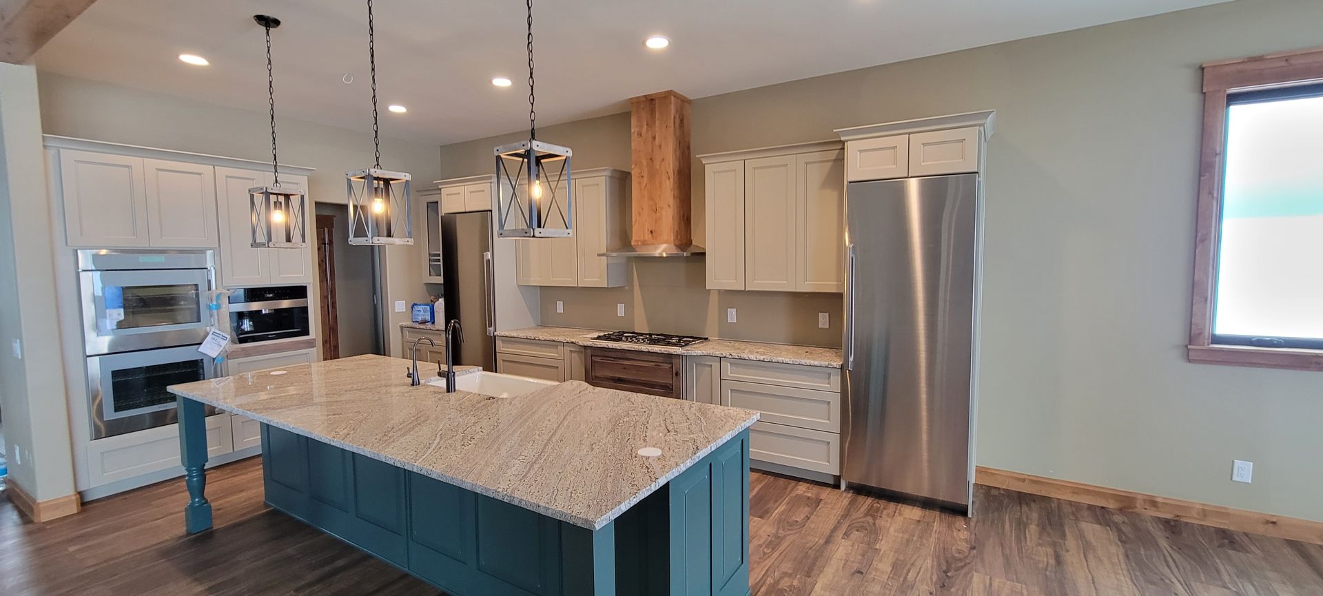 A kitchen with granite counter tops , stainless steel appliances , and a large island.