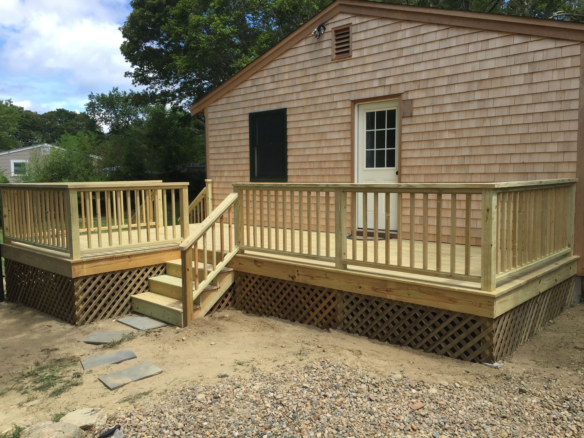 A small house with a wooden deck in front of it