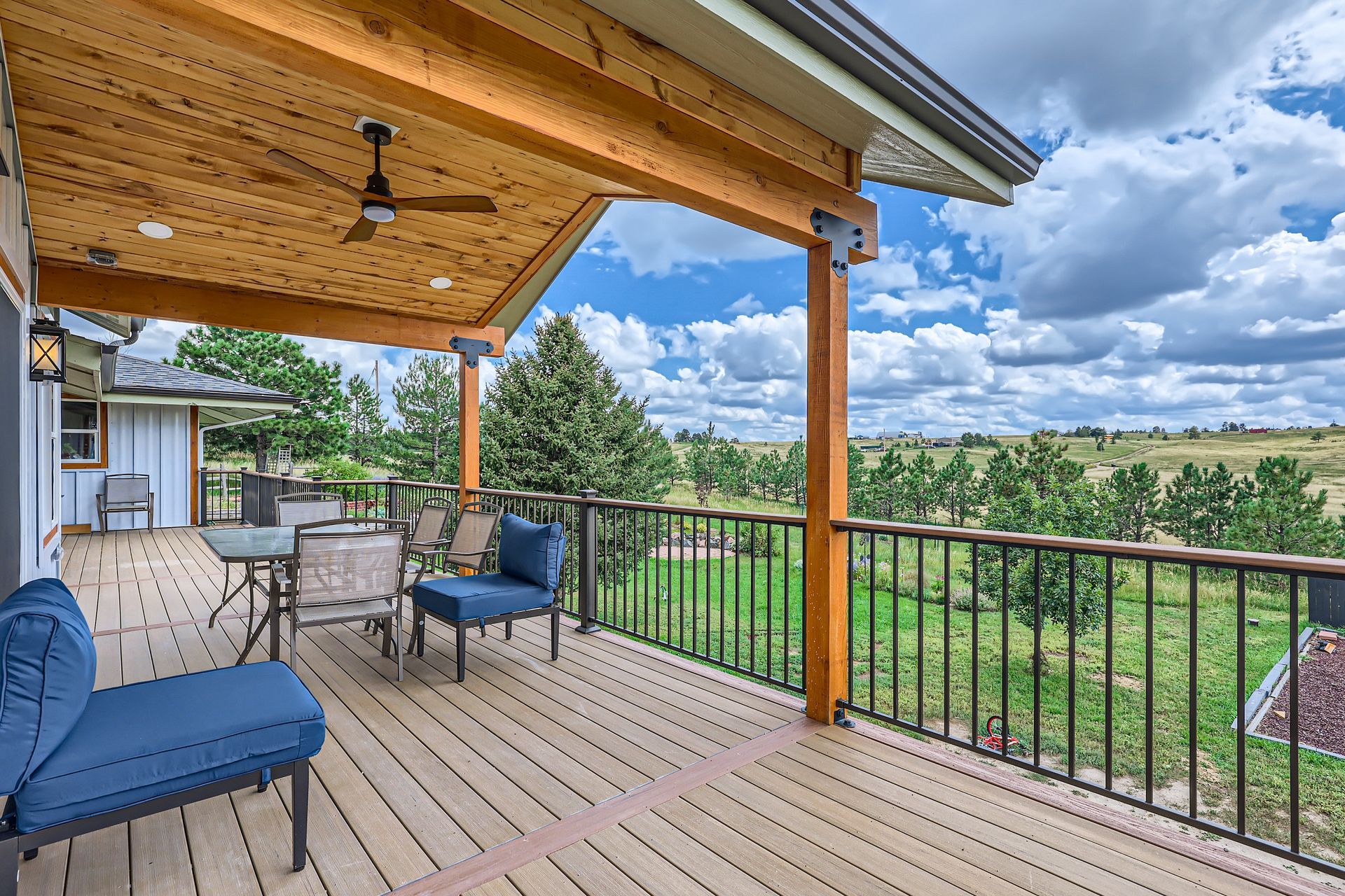 A large deck with a view of a field and trees.