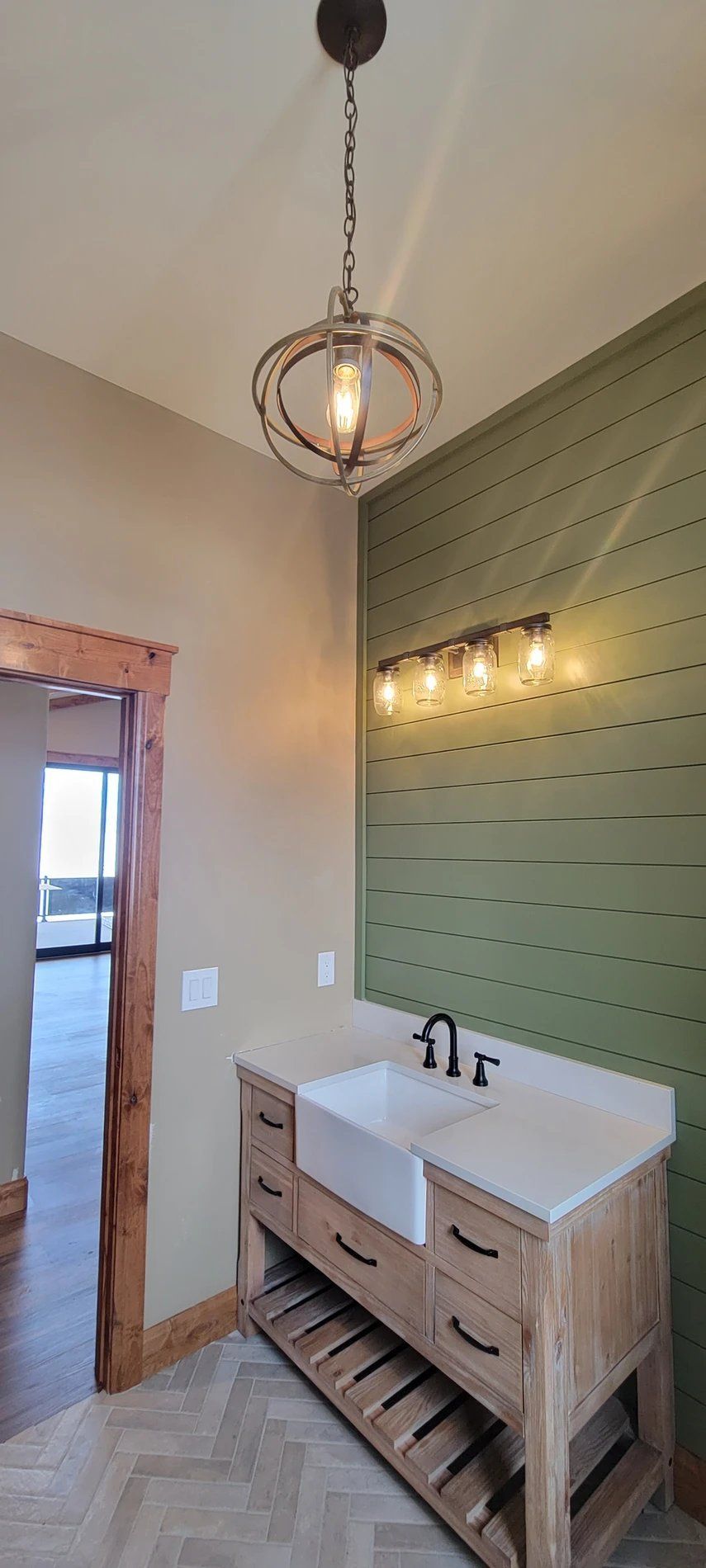 A bathroom with a sink and a light hanging from the ceiling.