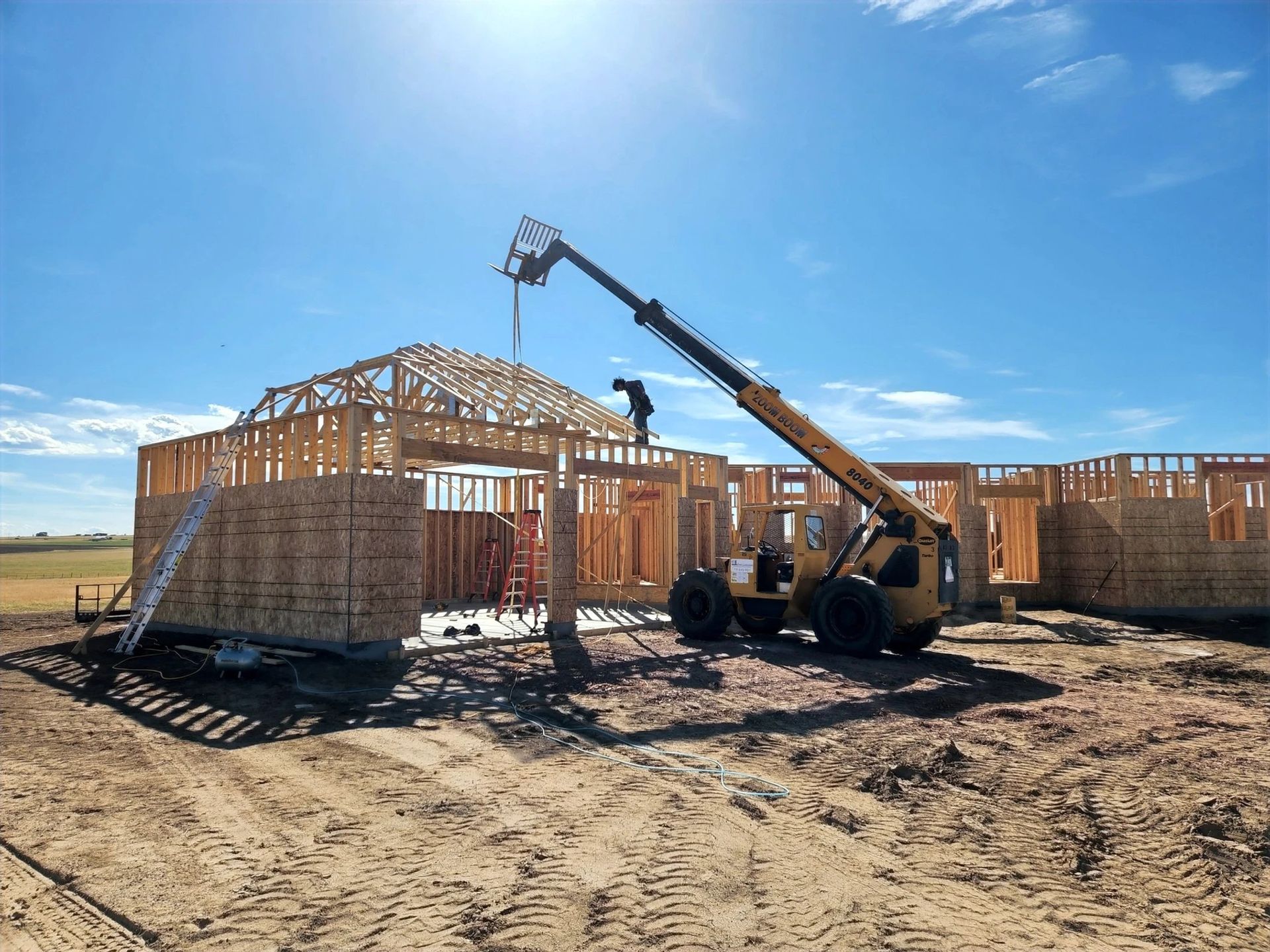 A construction site with a forklift and a crane.