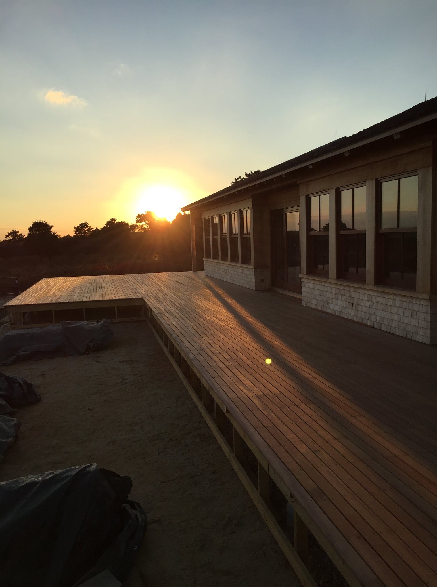 A house with a wooden deck and a sunset in the background