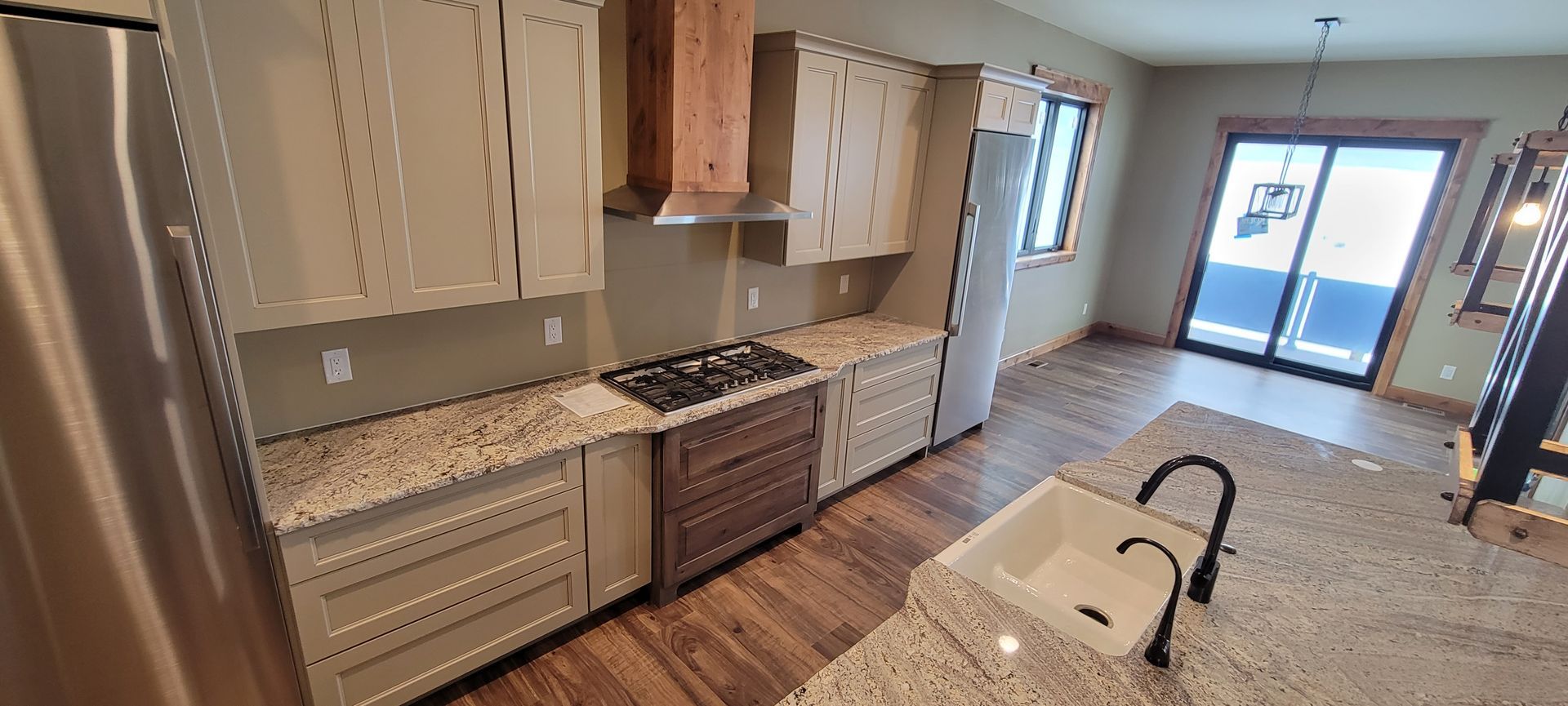 A kitchen with granite counter tops , stainless steel appliances , and a sink.