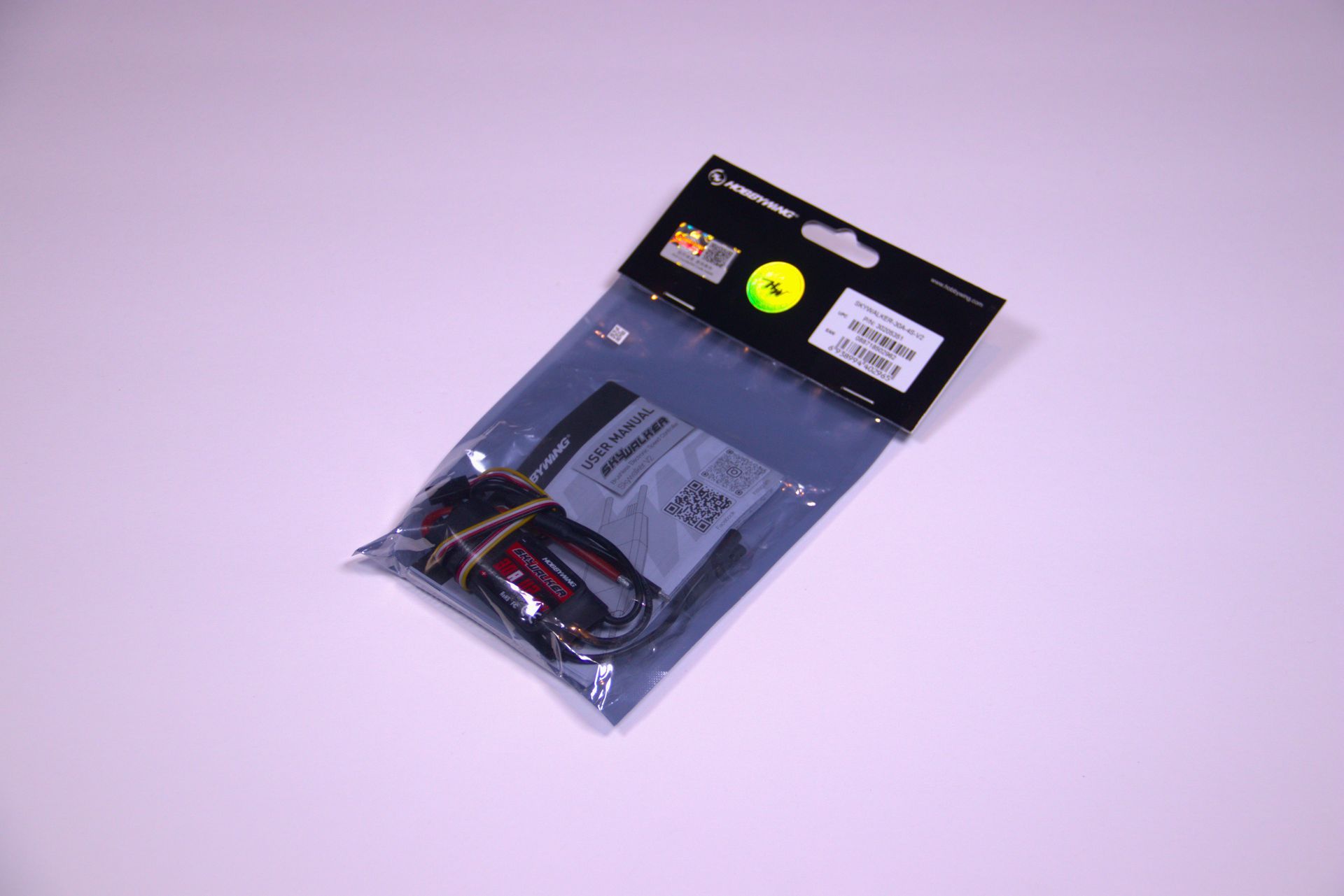 A sealed, semi-transparent plastic retail bag containing a small electronic cable, set against a plain light background.