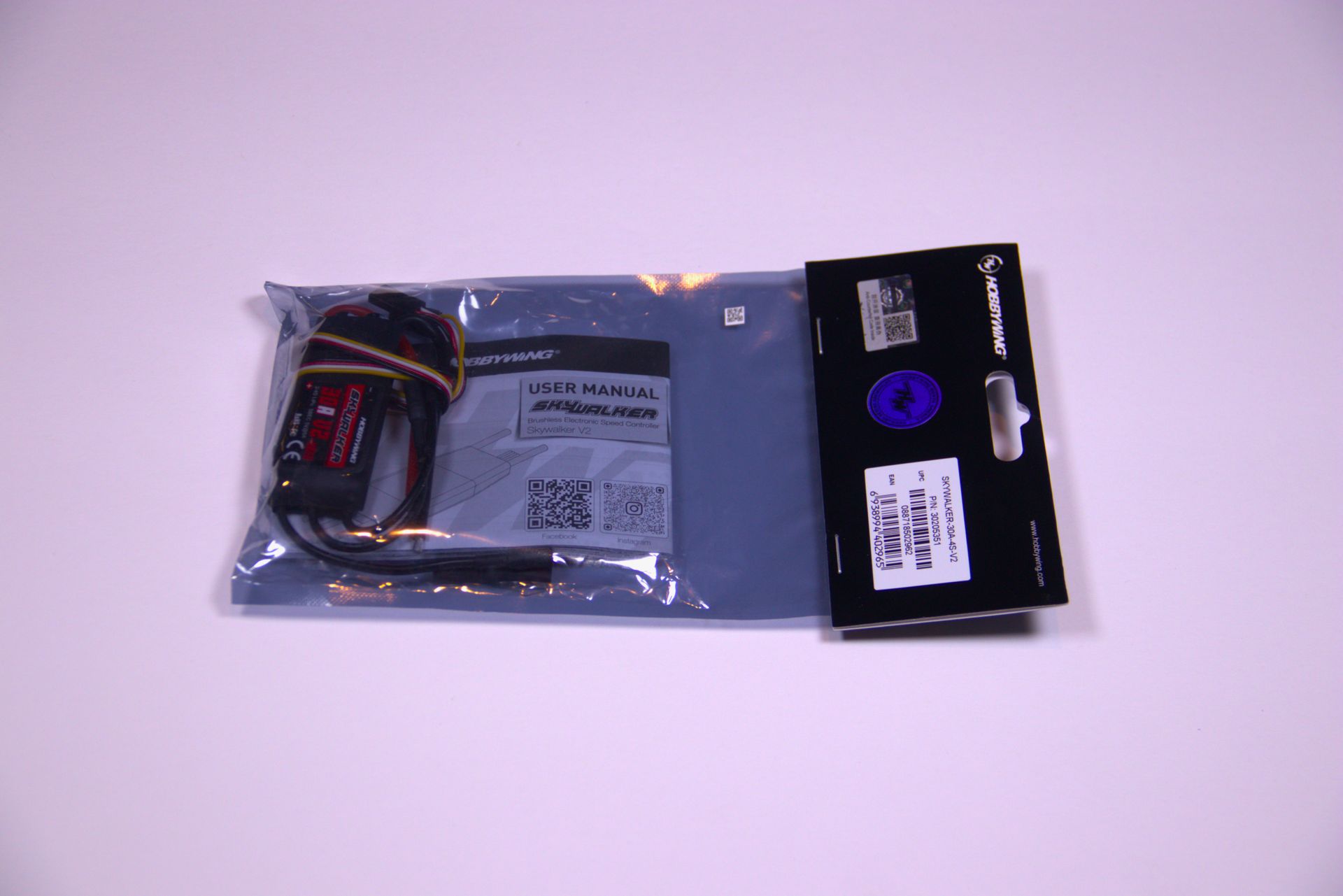 A sealed, semi-transparent plastic retail bag containing a small electronic cable, set against a plain light background.