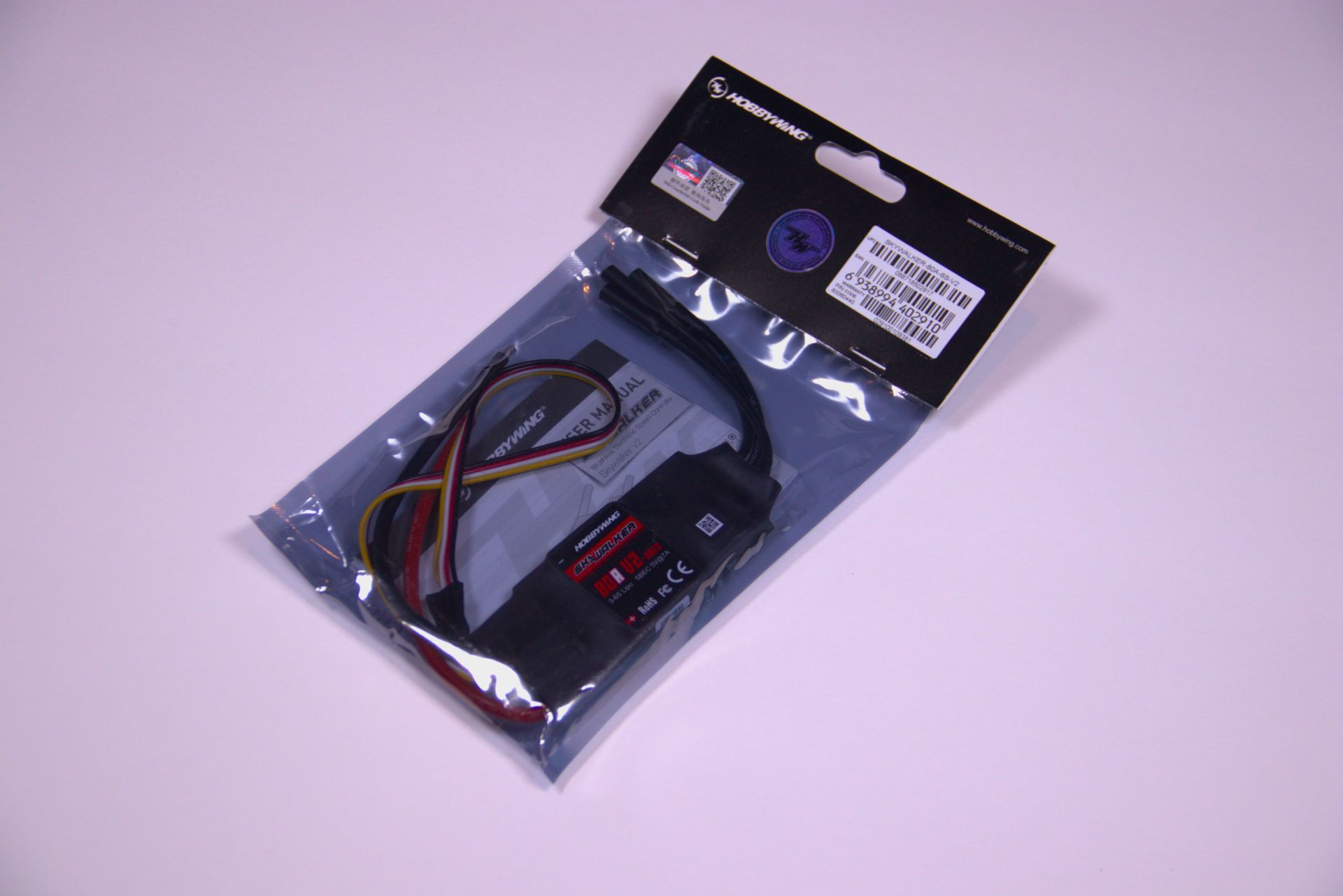 An electronic speed controller in its original plastic retail packaging against a plain white background.