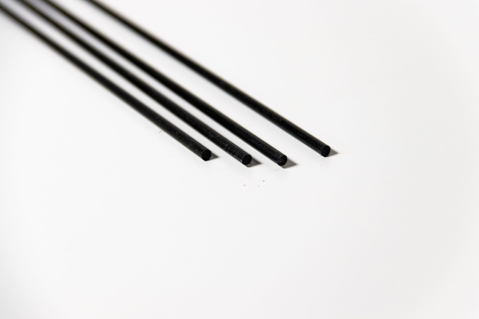 A close up of three black sticks on a white surface.