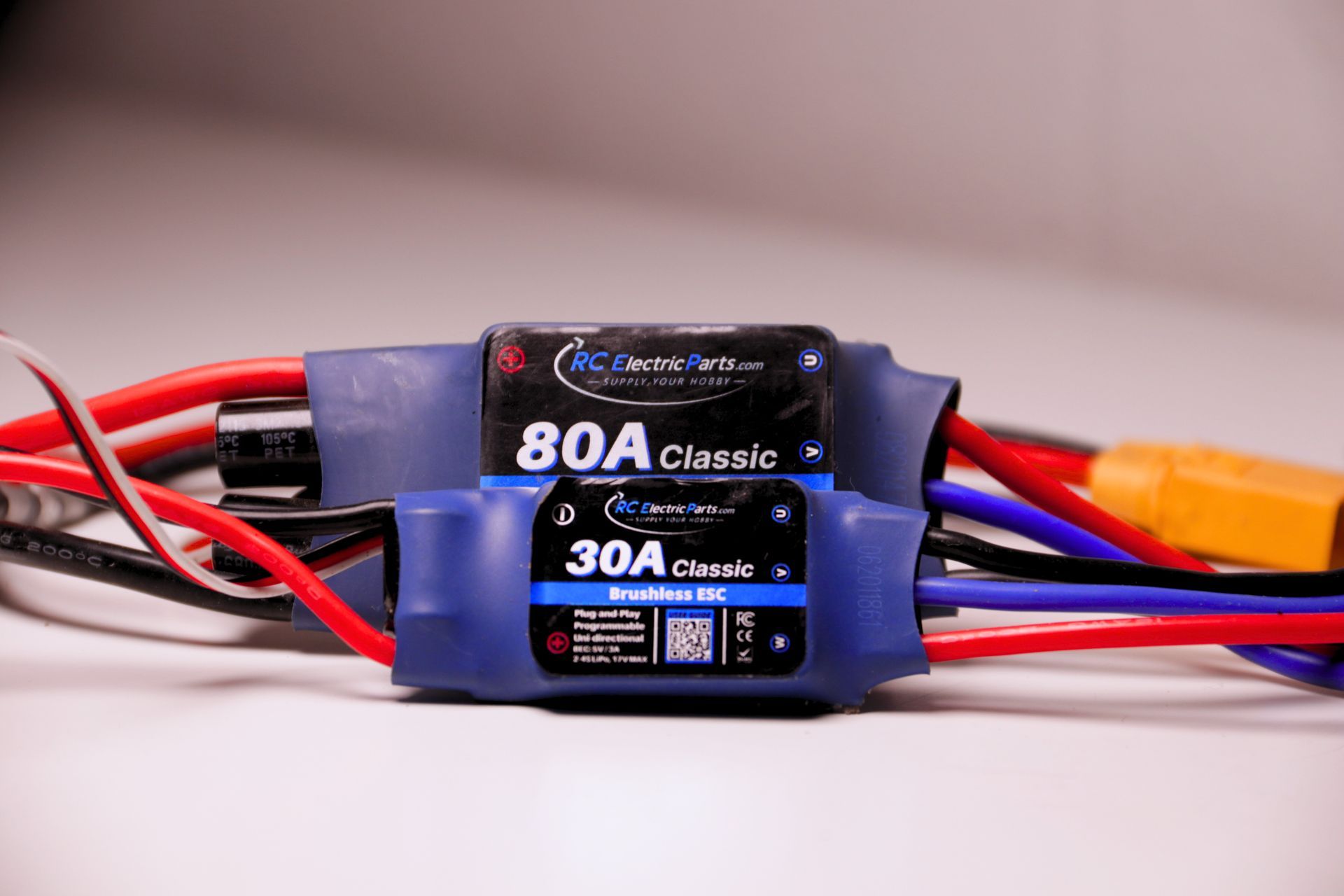 A pair of 80a classic brushless motors are sitting on a white surface.