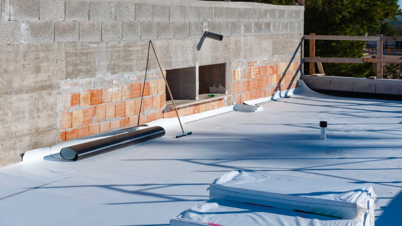 Construction site: a flat roof with white membrane, brick and concrete wall.