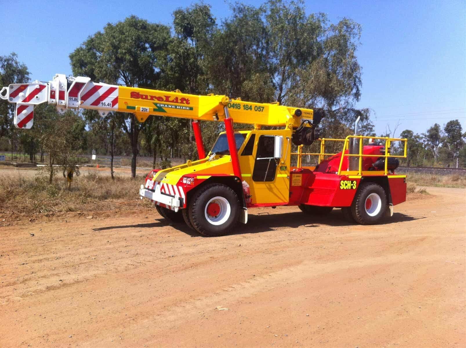 A Yellow And Red Truck With A Crane On The Back — Surelift Crane Hire In Moranbah, QLD