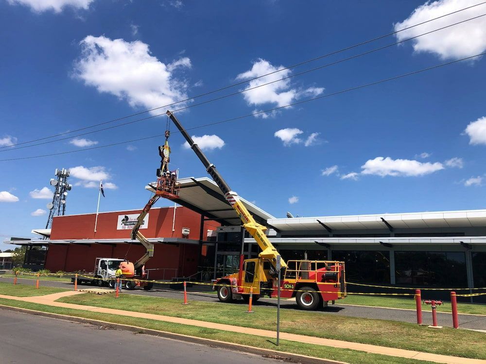 A Crane Is Being Used To Lift A Roof Of A Building — SureLift Crane Hire In Emerald, QLD