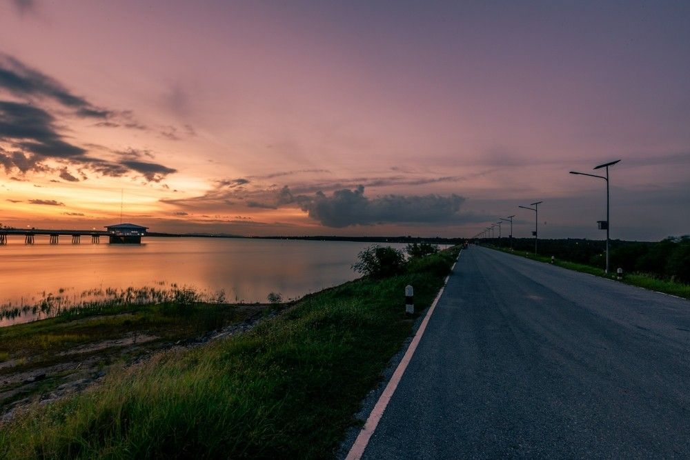 A Road Leading To A Bridge Over A Body Of Water At Sunset — Surelift Crane Hire In Nebo, QLD