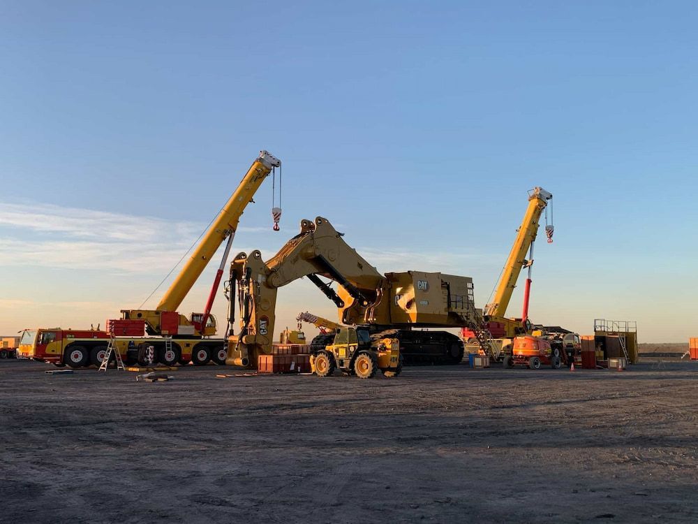 A Large Yellow Crane Is Sitting In The Middle Of A Dirt Field — SureLift Crane Hire In Moranbah, QLD