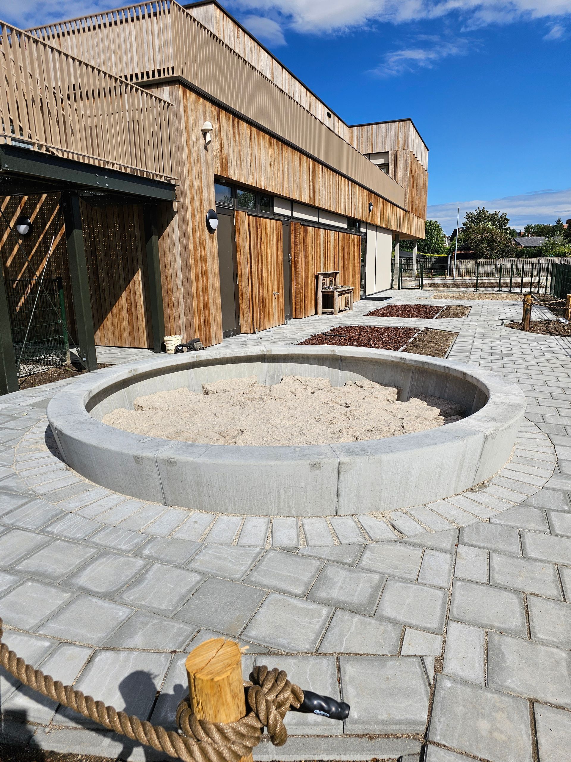 Een groot gebouw met een zandbak ervoor