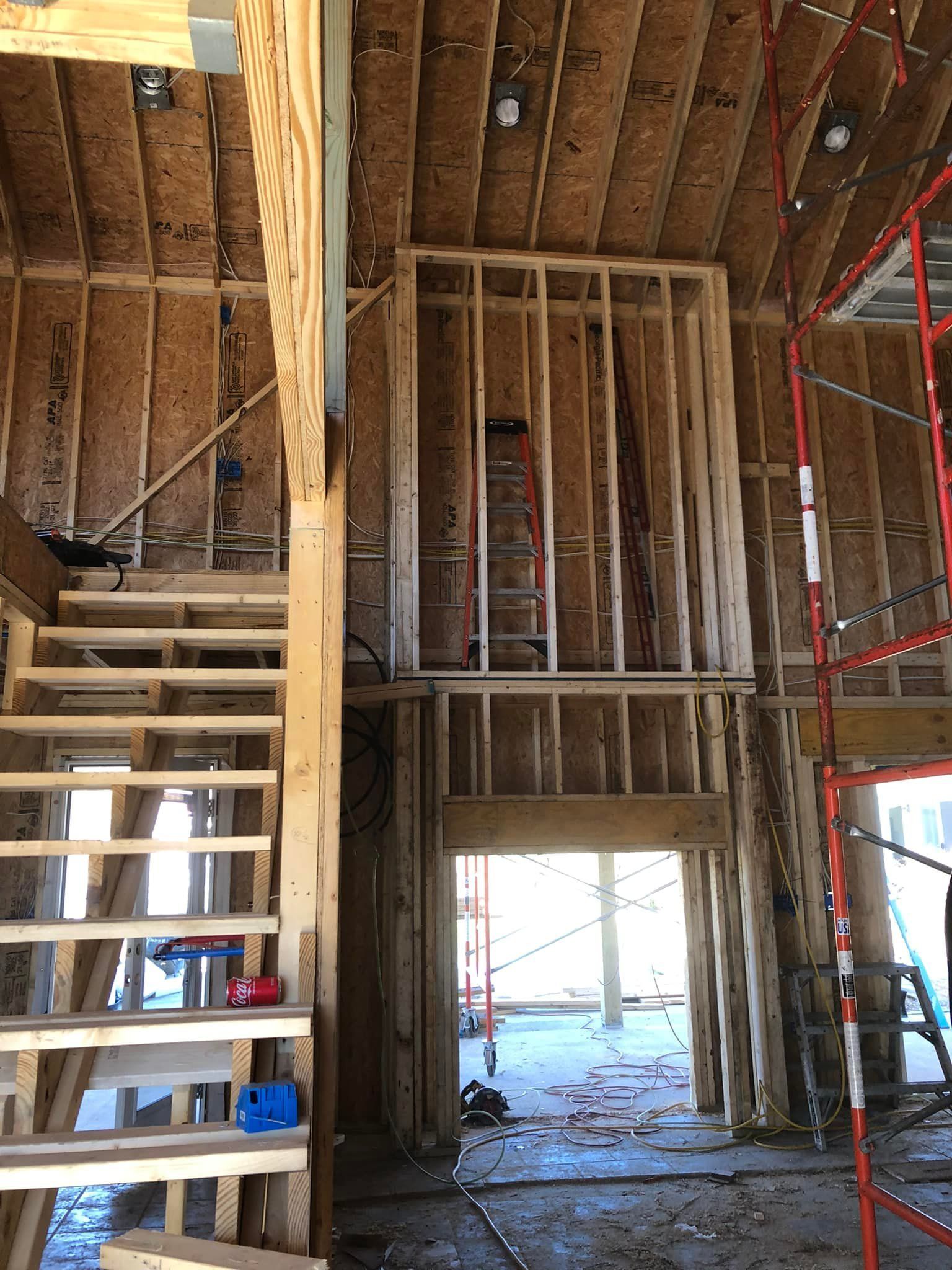 Interior of a building under construction with wooden framing for a staircase and walls.