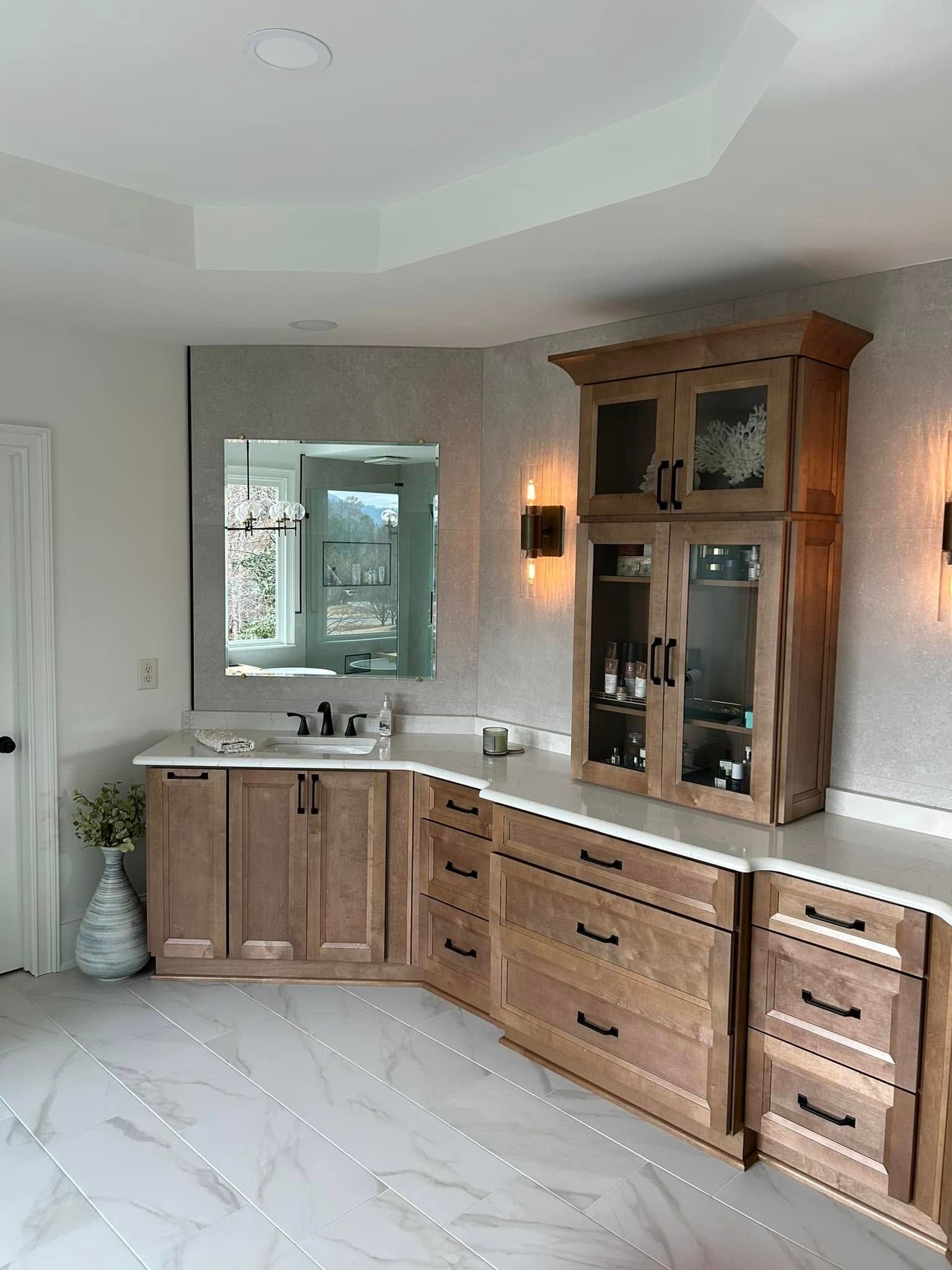 Bathroom with light wood cabinets, white countertop, and large mirror against a sparkly tile wall.