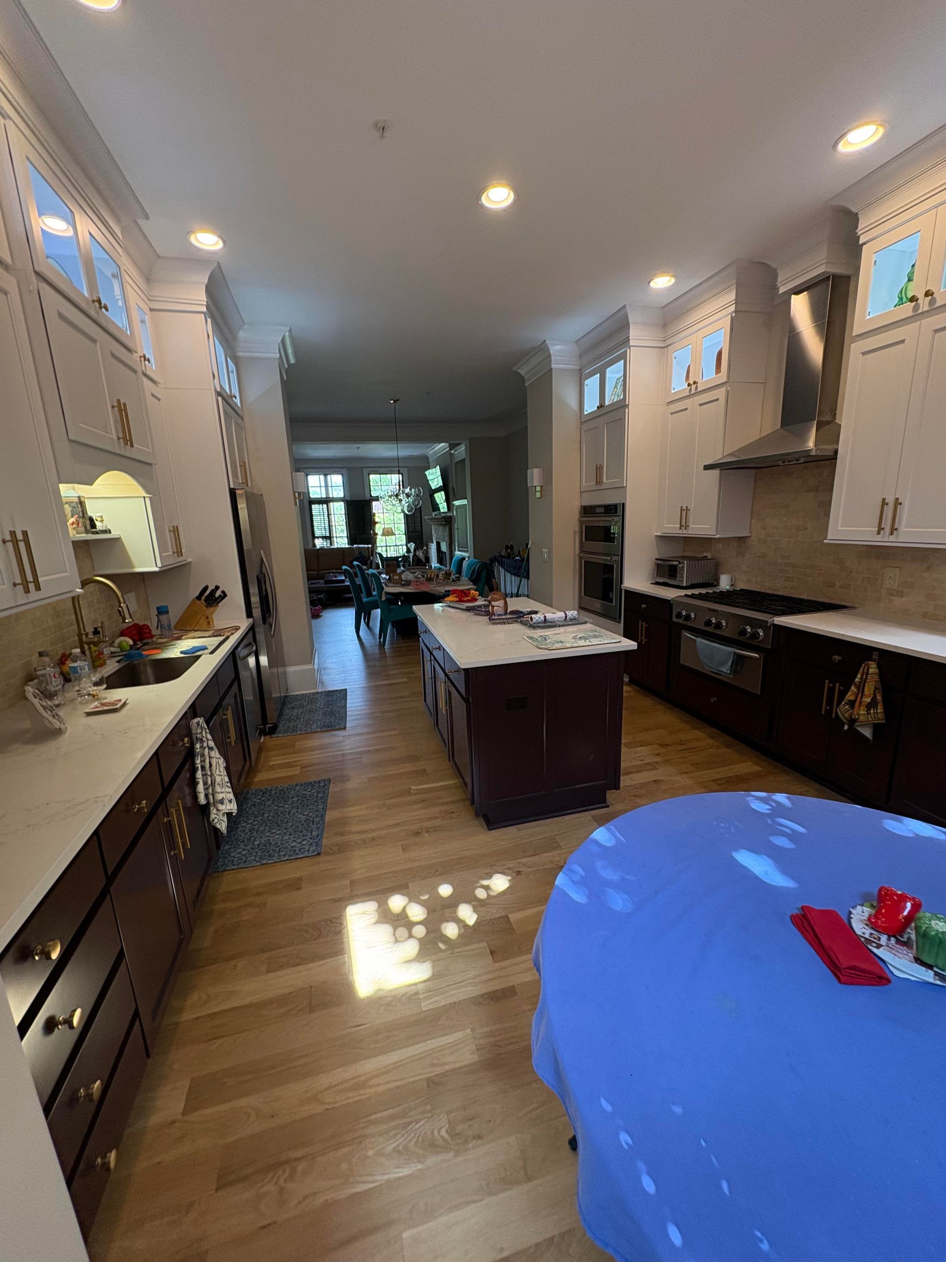 Spacious kitchen with a long island, dark wood cabinets, and light wood floors.