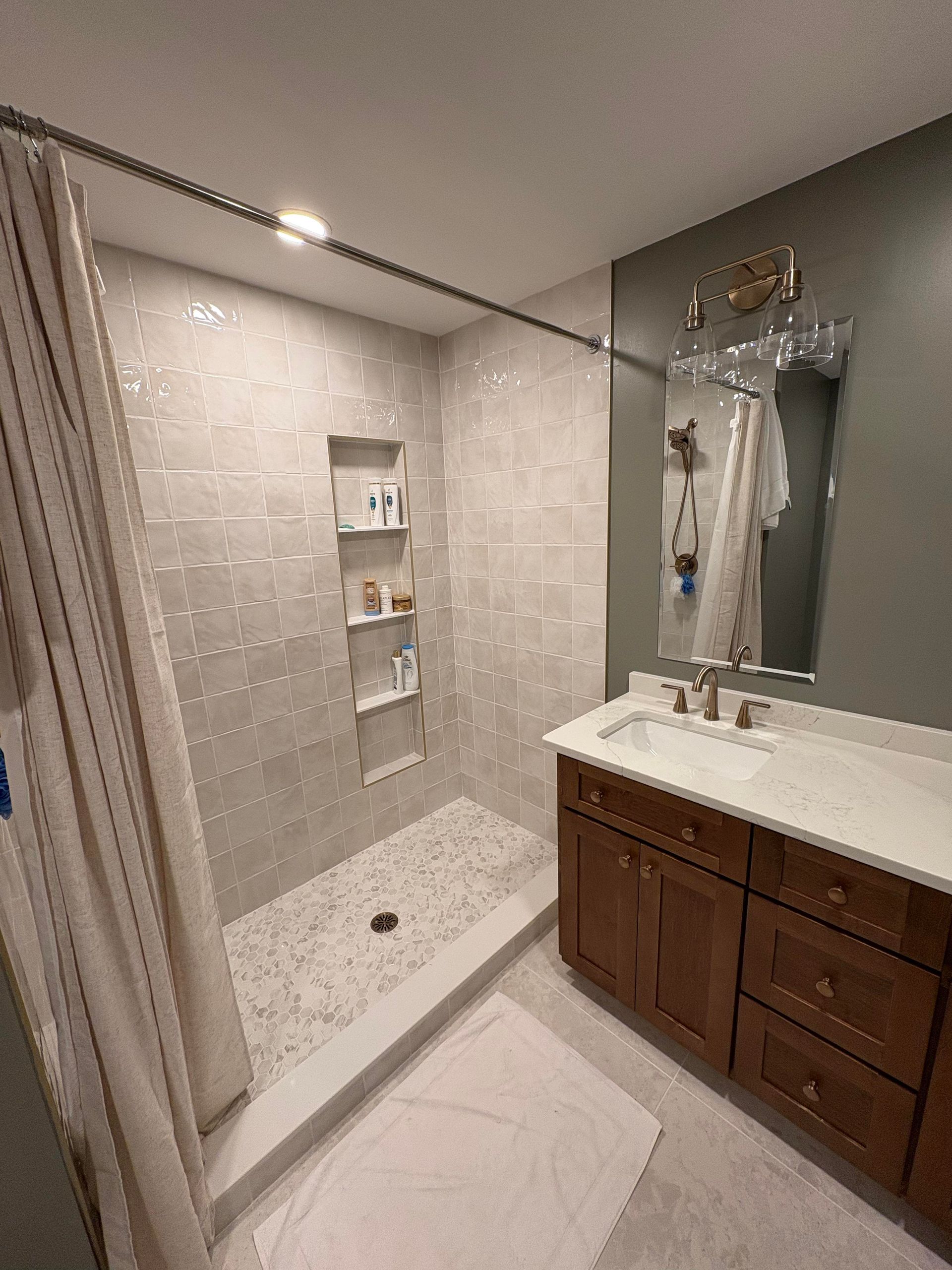 Modern bathroom with a tiled shower, vanity, and neutral color scheme.