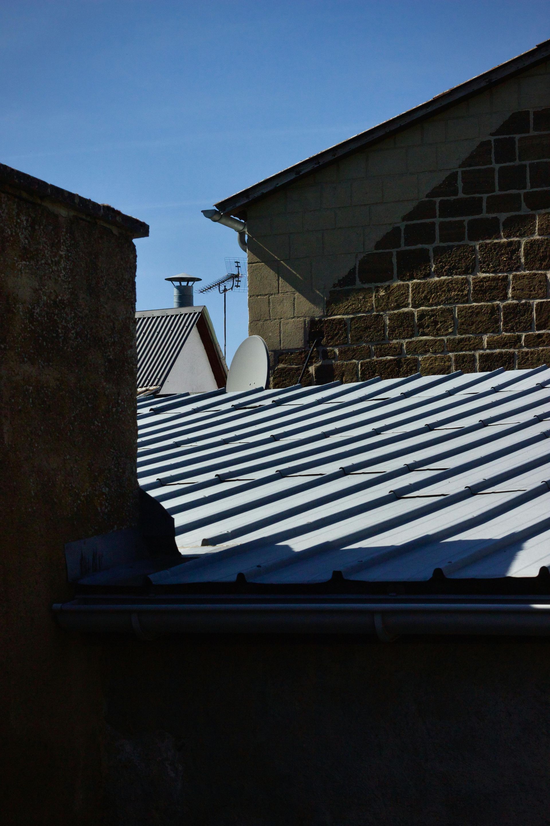 A white truck is parked in a parking lot next to a building.