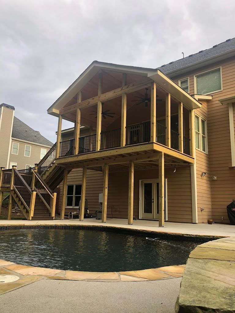 Two-story wooden deck and screened-in porch with stairs, overlooking a pool. Attached to a beige house.