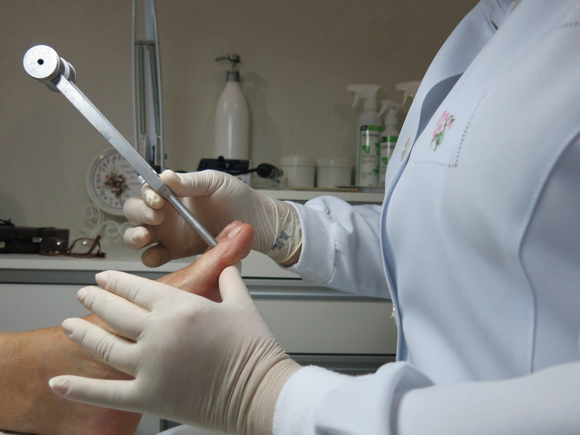 A podiatrist examines a patient's foot with a medical device. A podiatrist in West Chester, Ohio, examines a patient's foot with a medical device.