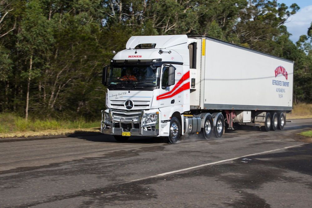 White Delivery Trucks Parked in a Row, Outdoors at Dusk — Hines Refrigerated Transport Pty Ltd in Forster, NSW