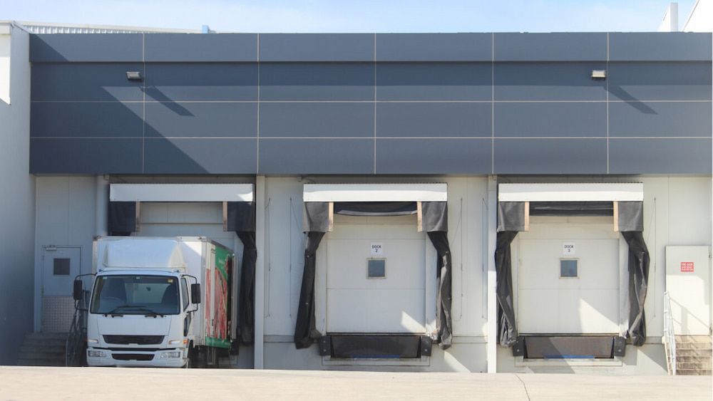 A Truck at a Loading Dock With Two Empty Docks on Either Side — Hines Refrigerated Transport Pty Ltd in Taree, NSW