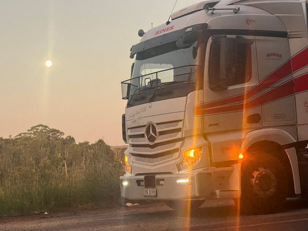 White Semi-truck on a Road at Sunset With the Moon Visible — Hines Refrigerated Transport Pty Ltd in Kundabung, NSW