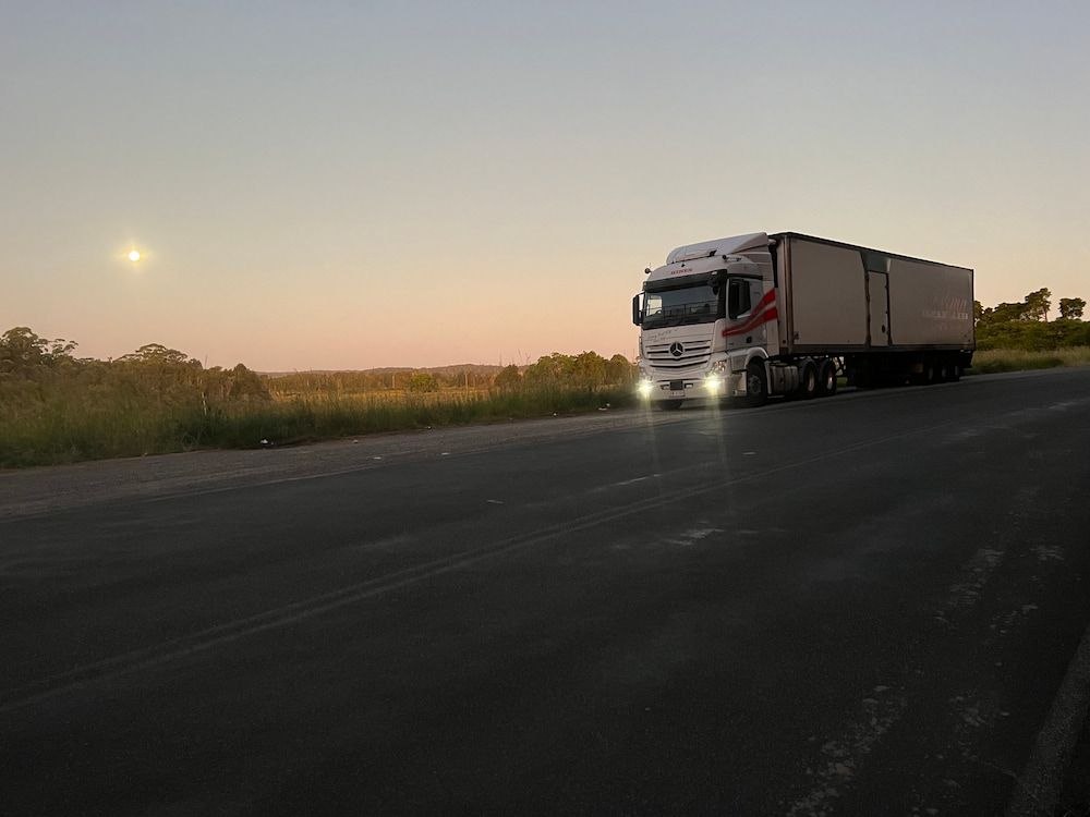 Semi-truck Driving on a Highway at Dusk — Hines Refrigerated Transport Pty Ltd in Maitland, NSW