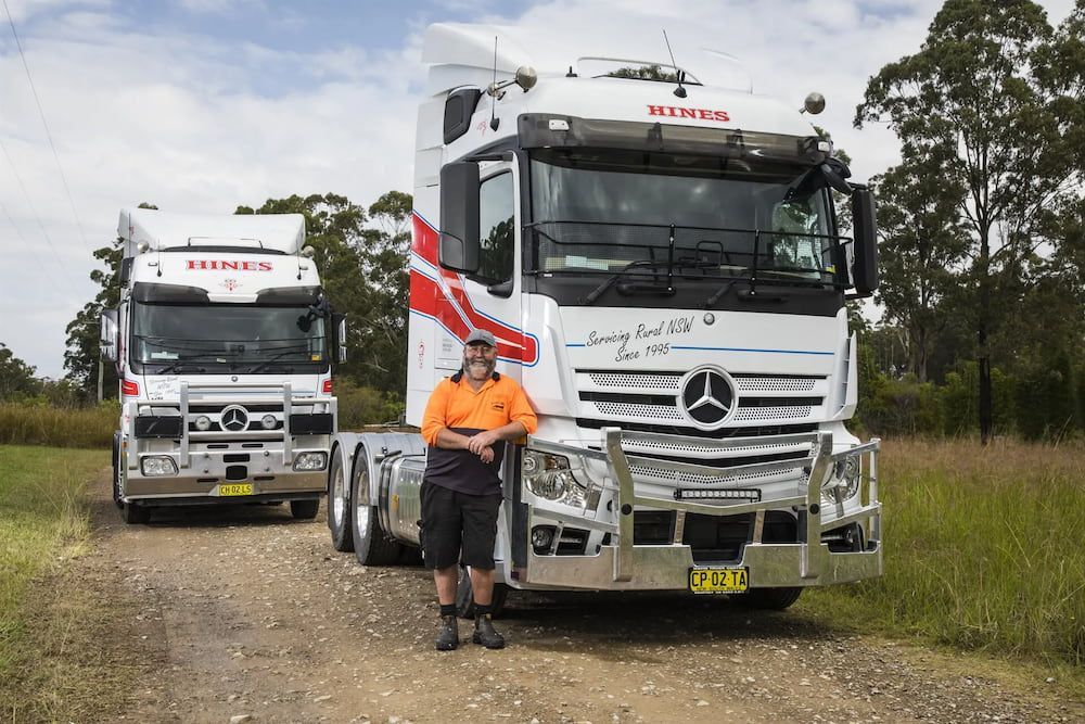 Man Standing in Front of a White Truck on a Dirt Road — Hines Refrigerated Transport Pty Ltd in Kundabung, NSW